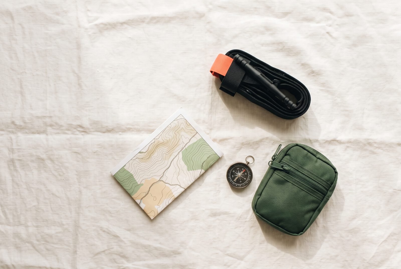 Tourniquet laid out with a trail map, compass and pouch
